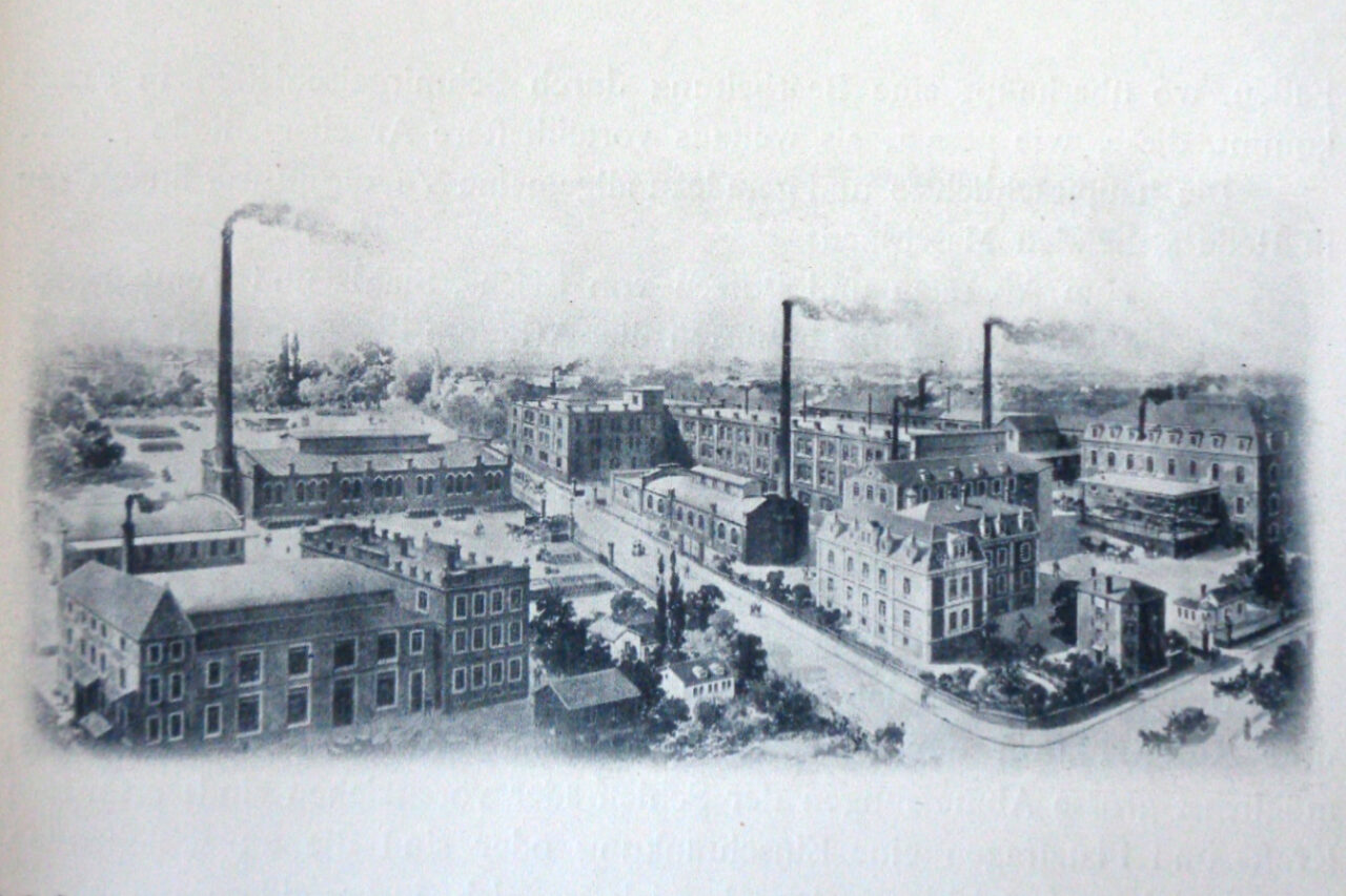 Historische Abbildung der Naxos-Union-Fabrik in Frankfurt am Main vor 1906 mit mehreren Fabrikgebäuden, Schornsteinen und umliegenden Straßen.